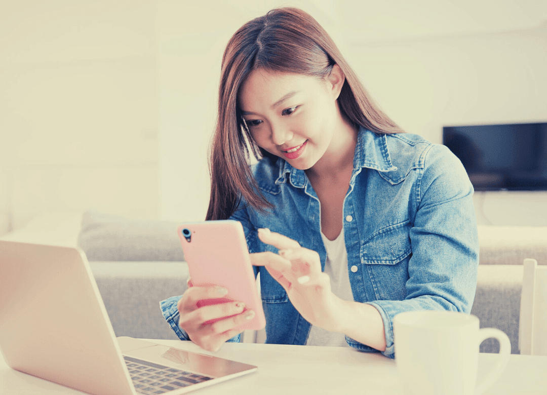 Woman looking at phone, laptop and TV