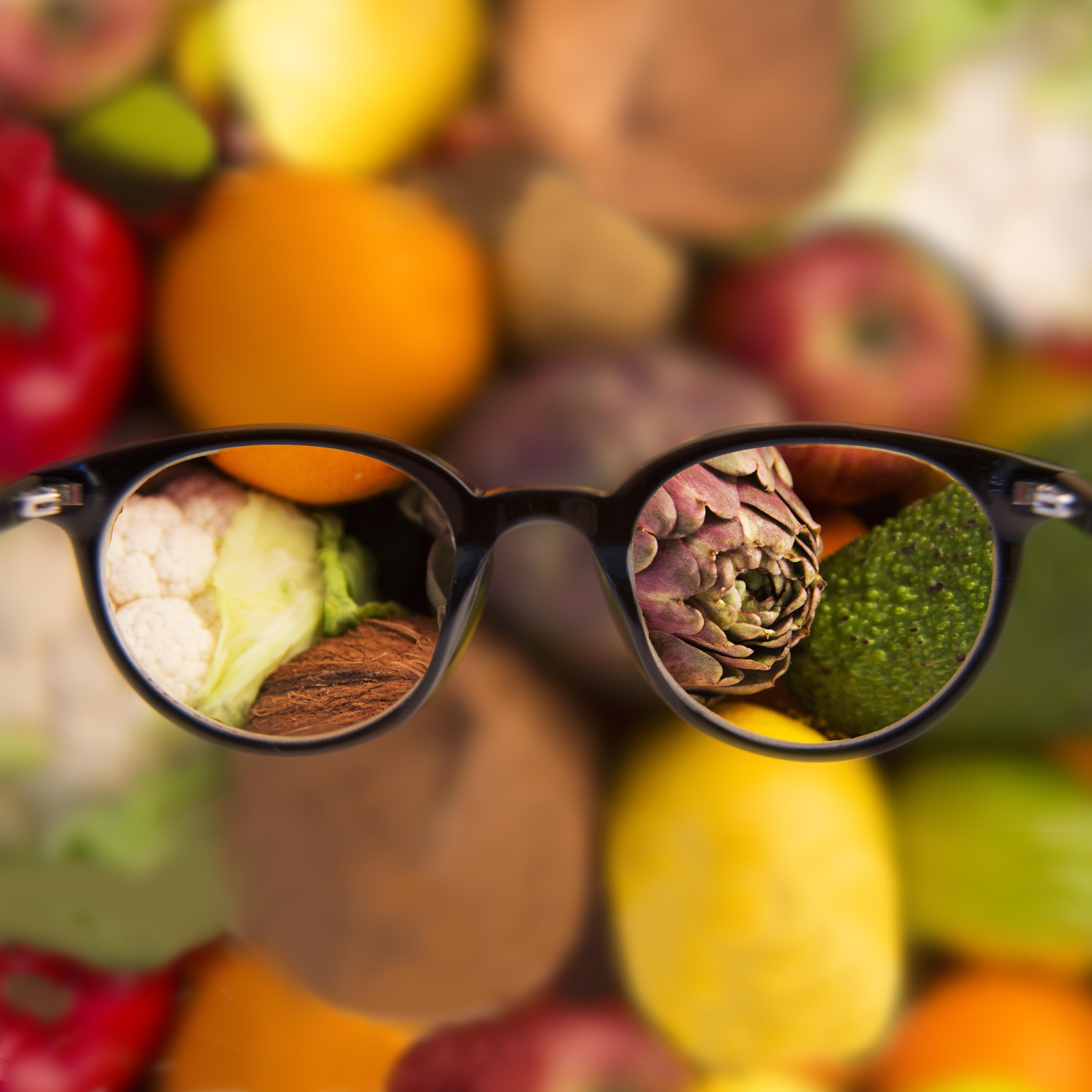 A pair of glasses reflecting a colorful assortment of fruits and vegetables