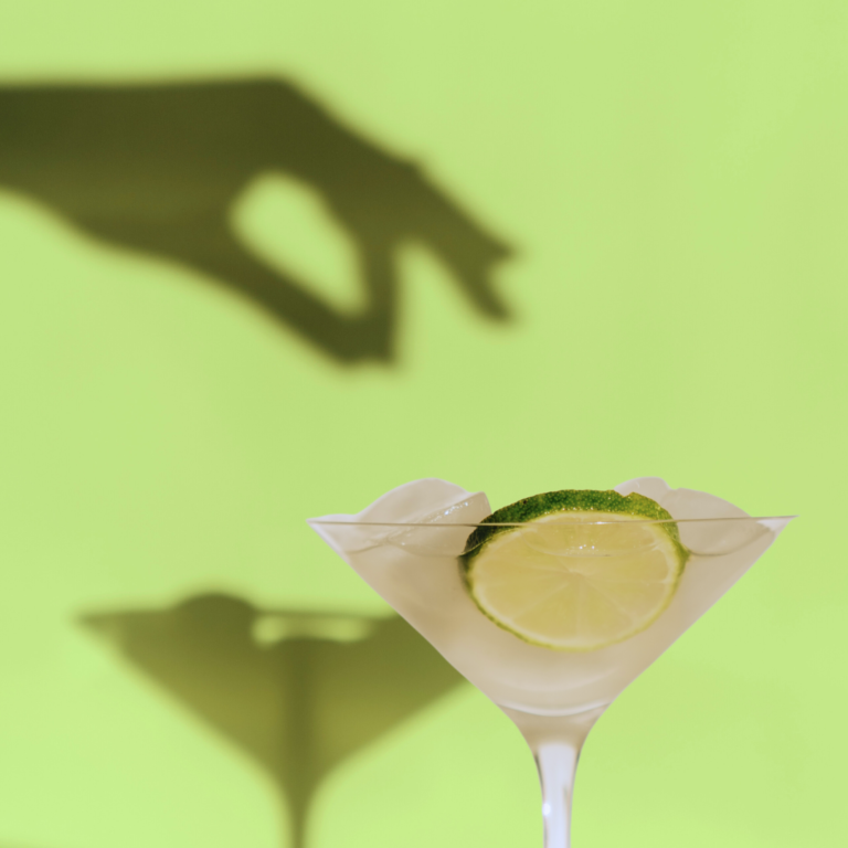 Martini with an ominous shadow of a hand in the background